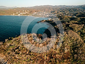 View of Sayulita Mexico beach looking northeast. Aerial view at sunset with waves crashing at point