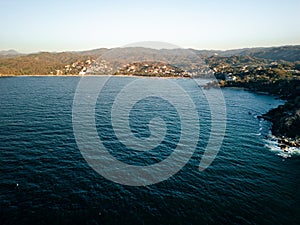View of Sayulita Mexico looking east. Aerial view at sunset with waves crashing at point