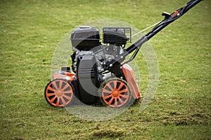 view of a scarifier removing moss from the lawn