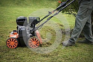 view of a scarifier removing moss from the lawn