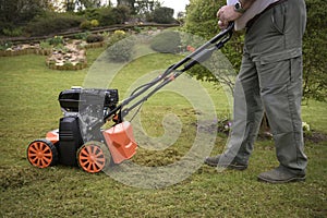 view of a scarifier removing moss from the lawn