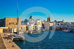 View of scenic city scape and a fishing harbor with marina in Monopoli, Italy