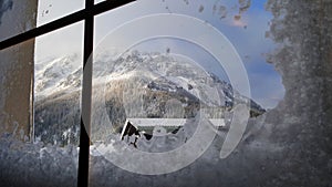 View of the Schneeberg mountain through an icy window