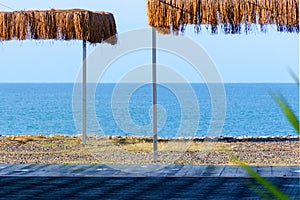 View of the sea beach with thatched canopies.