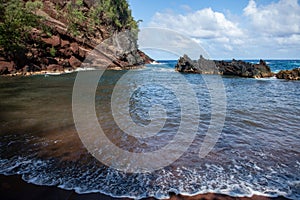 View of sea beach with waves and rocky coast. Red Sand Beach, Maui in in Hawaiian.
