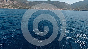 View of the sea beyond the stern of a moving yacht on a sunny summer day