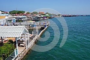 View of the sea and the coastline covered by Buildings, fisher Village on the Island Koh Larn