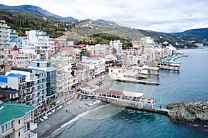 View from the sea on the embankment of the resort village of Utes in the Crimea with colorful facades of buildings. All-season per