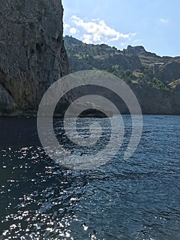 View from the sea of the high impregnable rocks of the mountains on the sea coast. A picturesque sea voyage