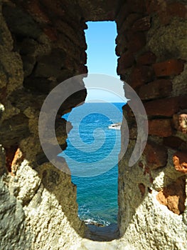 A view of the sea through the loophole of a medieval fort in the southern part of Colliure, France