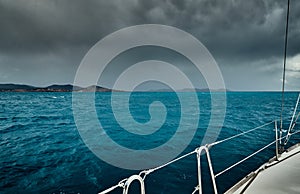 The view of the sea and mountains from the sailboat, edge of a board of the boat, slings and ropes, splashes from under