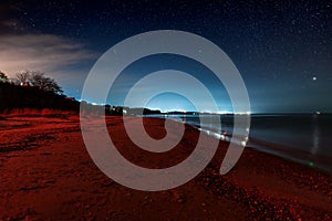 View of the sea at night with red light at the beach. Ochakov. Ukraine photo