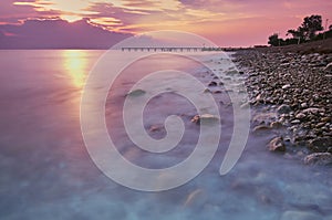 Sunset or sunrise landscape, panorama of beautiful nature, beach with colorful red, orange and purple clouds reflected in the ocea