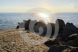 View of the sea with rocks and orange sky. Rock formation in coastal water in Thailand