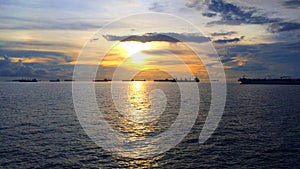 View of the sea with silhouettes of ships at sunset.