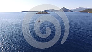 View from the sea to the island of Mamula in Montenegro and yacht near it