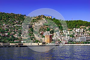 View from the sea to the Old City of Alanya Turkey. Kizil Kule, Alanya Kalesi, ancient wall and modern cottages on the