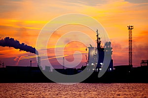 View on seaport with ship silhouette at sunset. Evening panorama of the cargo port