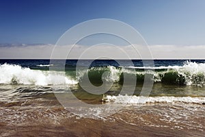 A view of a seascape, Pacific ocean, waves and foams and splash in Malibu, California