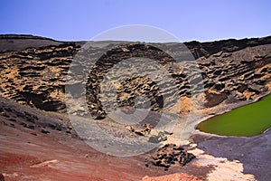 View on secluded deep green lake Lago verde in lagoon surrounded by impressive cliffs - El Golfo, Lanzarote