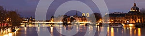 The view of Seine river at night with some touristic bridges like Pont des Arts and Pont Neuf, building of French Academy, Paris,