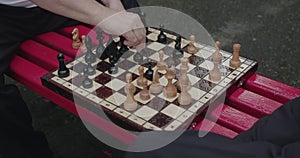 View of senior playing the chess and talking. Man makes a move and rejoices