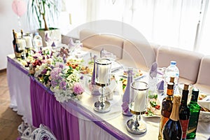 View of the served for decorated wedding dinner table in elite restaurant with beautiful flowers