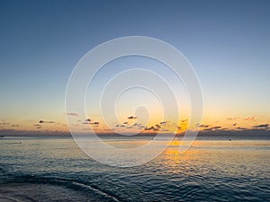 A view of Seven Mile Beach in Grand Cayman Island with a beautiful sunset