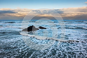 View of several large sea stacks in the ocean at Cannon Beach, Oregon.