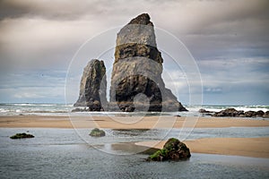 View of several large sea stacks in the ocean at Cannon Beach, Oregon.
