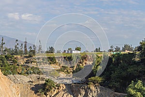 View of several mountains, various vegetation, some houses and the morning sky