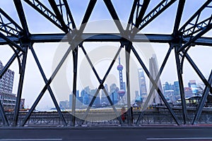 view of Shanghai cityscape with steel bridge structure, high rises office and towers of the Business district skyline at mist