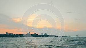 View from the ship to the shore on the horizon at sunset. The city of Odesa in Ukraine is a view from the sea. Warm sky