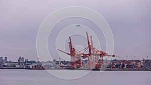 A view at shipping dock of port of Vancouver with helicopter above port crane