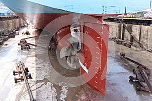 View on the ships rudder and propeller. Ship in a dry dock.