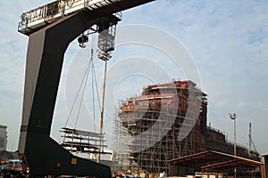View of shipyard with straddle crane and ship under construction
