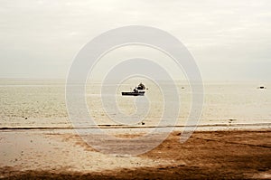 View from shore on fishing boats in the ocean, beautiful cloudy