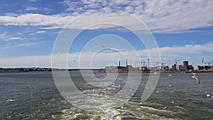 View of the shore and ocean from the stern of the ship.View of the waves following the ship in sunny weather.