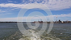 View of the shore and ocean from the stern of the ship.View of the waves following the ship in sunny weather.