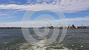 View of the shore and ocean from the stern of the ship.View of the waves following the ship in sunny weather.