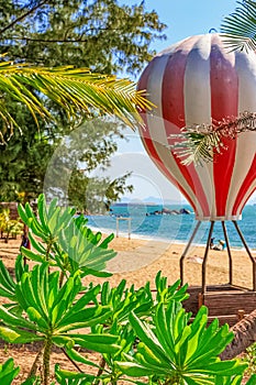 View of the shore of the South China Sea with a sandy beach, palm trees and a hot air balloon, Sanya