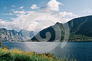 View from the shore to the sea against the backdrop of a forested mountain range