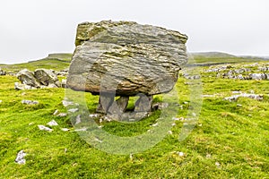 A view showing a glacial erratic supported on the limestone pavement on the southern slopes of Ingleborough, Yorkshire, UK