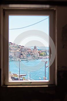 View of the Sibenik city from a nearby building framed in the window frame. Old city on the coast of the adriatic sea, cathedral