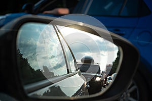 View in the side mirror of a car on the road. Traffic congestion, a large congestion of cars, difficult traffic