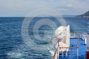 View from the side of a sea ship on the blue sea and the waves behind it