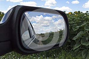 A view in the side view mirror. Reflection of the country road