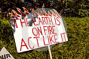 View of sign The Earth is on Fire, Act like it as part of Global Climate Strike