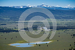 View from the SIgnal Mountain overlook in Grand Teton National Park - large forested area, with the Snake River flowing through