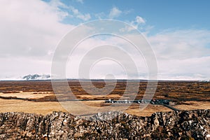 View from the Silfra Fault, in the Tingvedlir Valley in Iceland, the vast expanses of fields with yellow grass, car